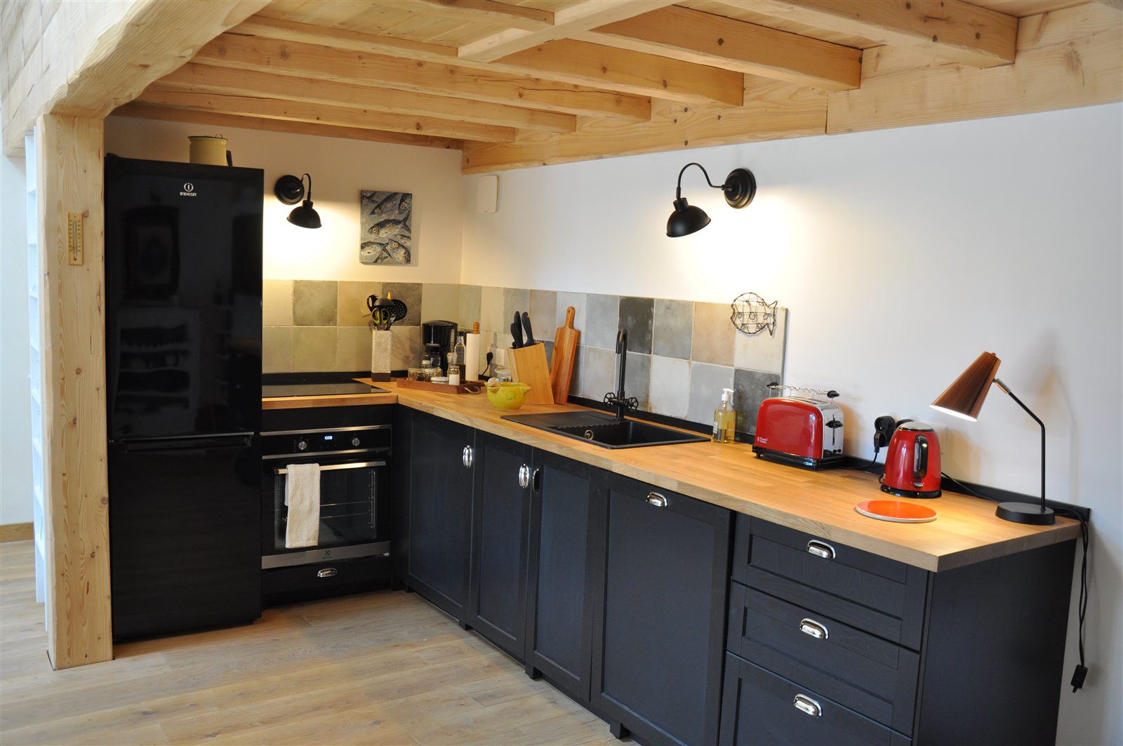 Cuisine aménagée avec façades sombres et plan de travail en bois