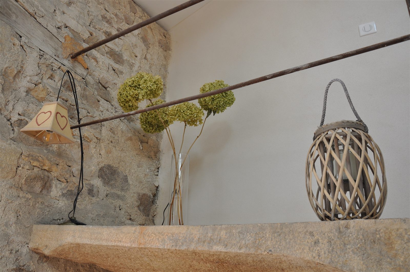 Objets décoratifs et branches fleuries devant un mur en pierre