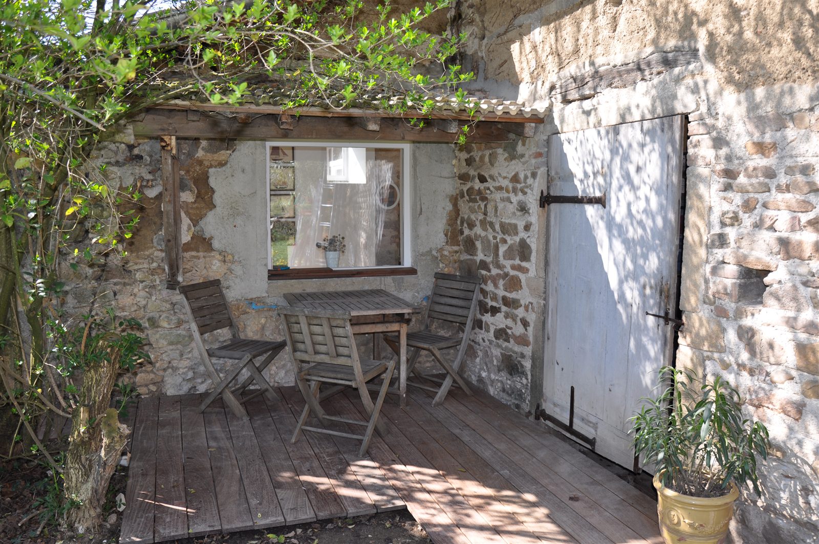 Petit salon de jardin contre un mur en pierre