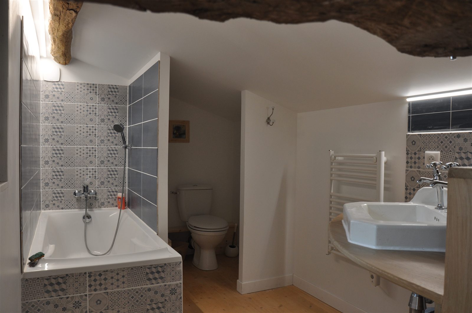 Salle de bains avec baignoire et poutre ancienne